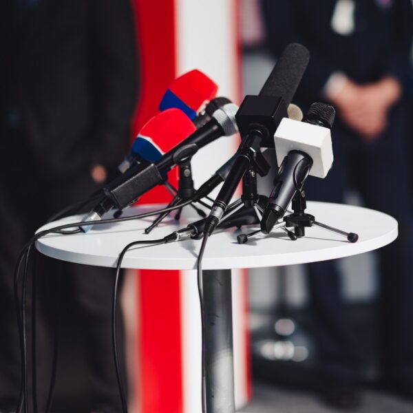 Press conference, microphones at a table